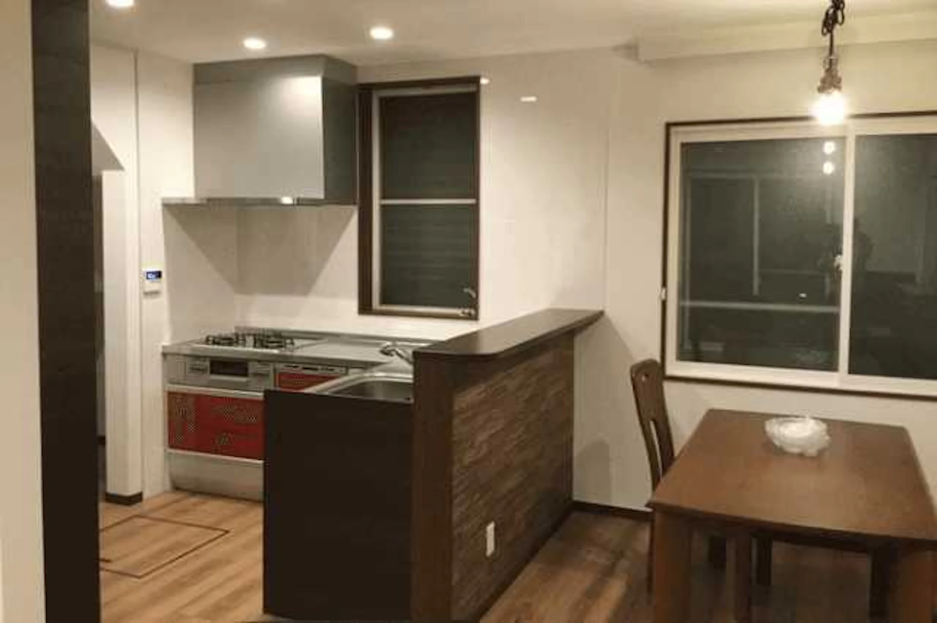 茶色と白で統一されたL型キッチン、テーブルや椅子の写真