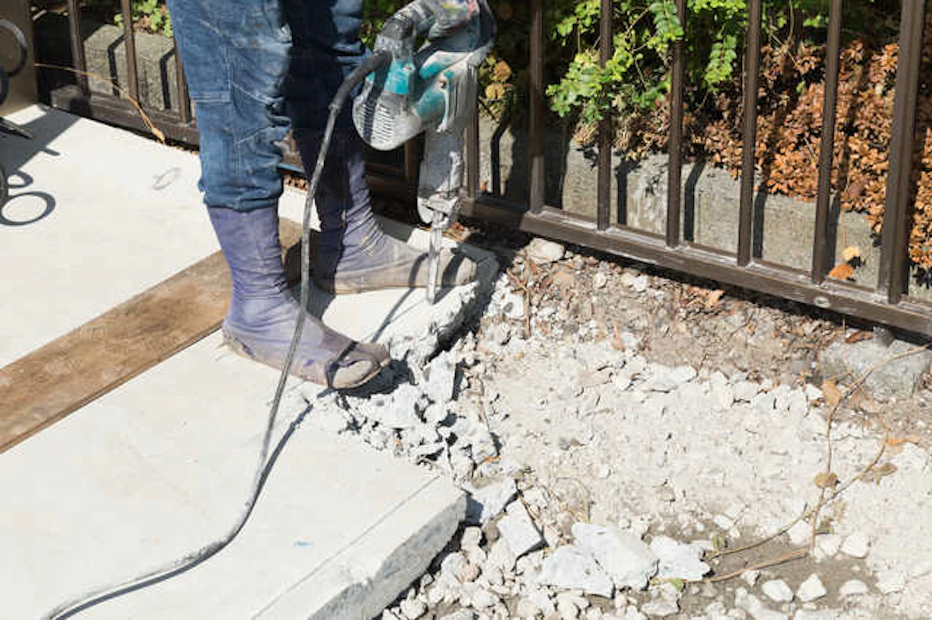 庭のコンクリートを機械で壊す作業員の足元