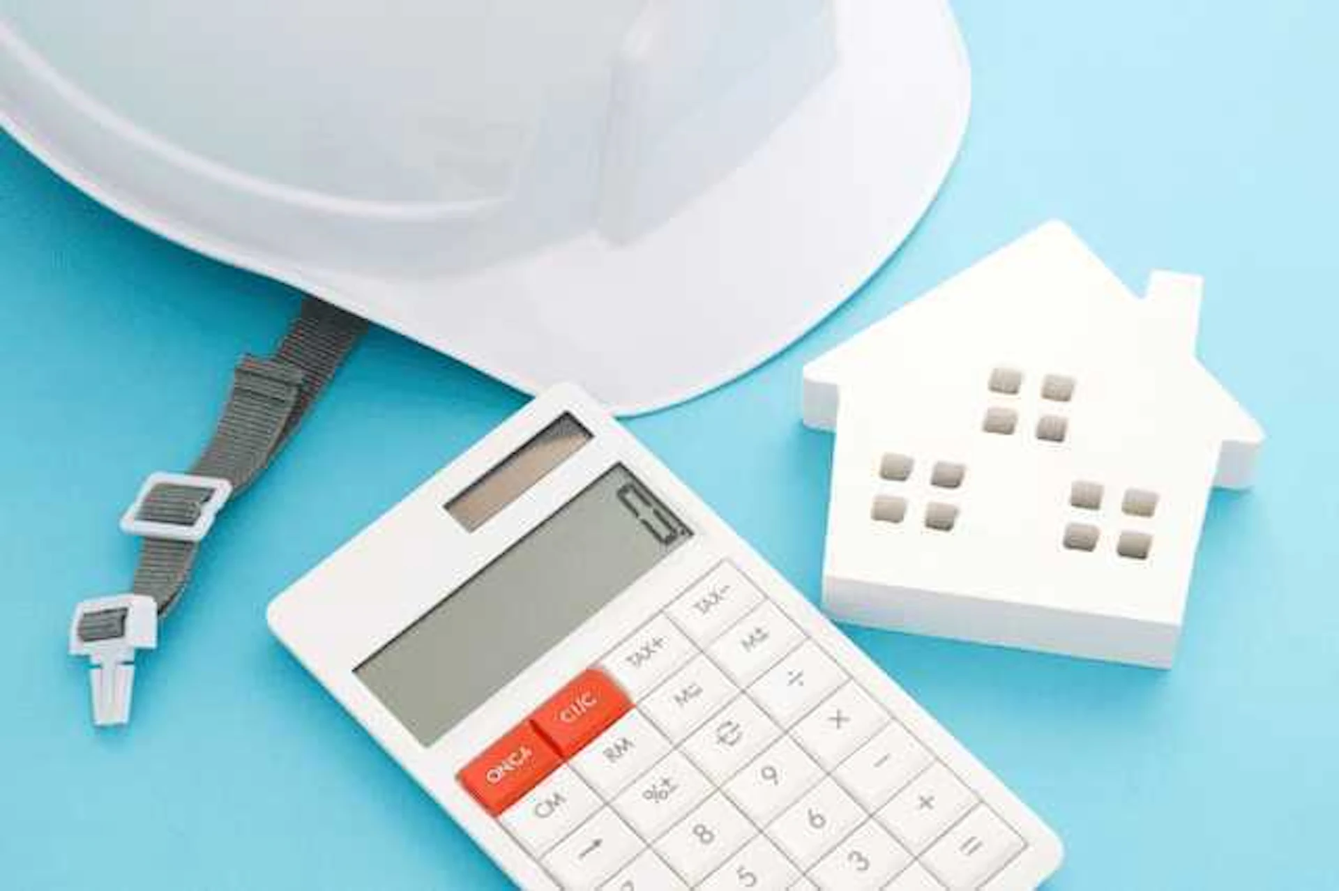 宅所にヘルメット、電卓、家のオブジェがある