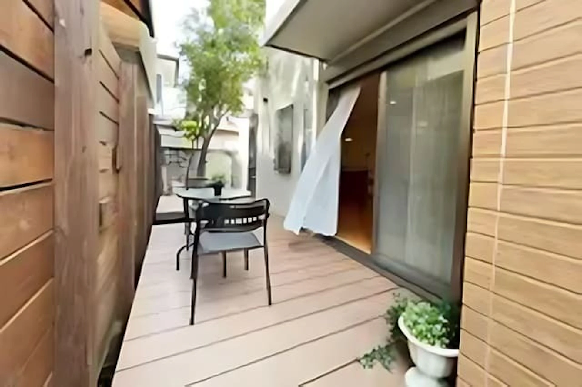 リビングからつながるウッドデッキ　テーブルセットが置かれている