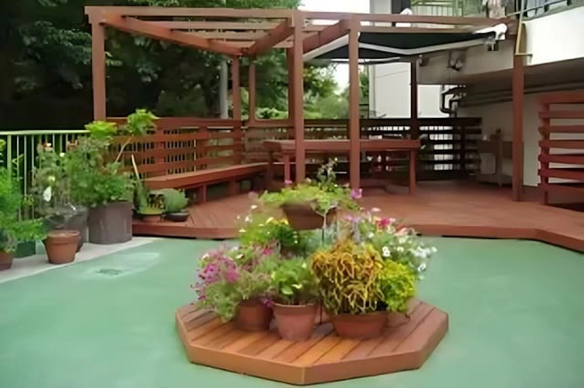 植栽があしらわれた広いウッドデッキ