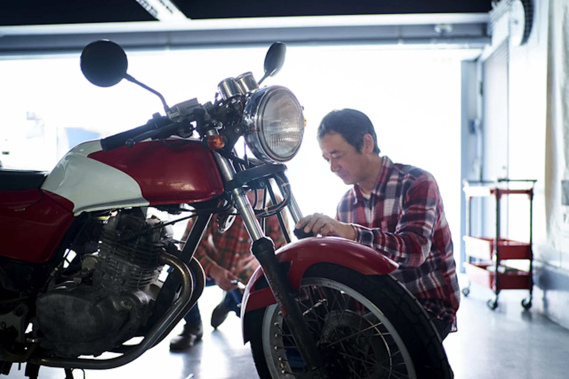 バイクのメンテナンスをする男性