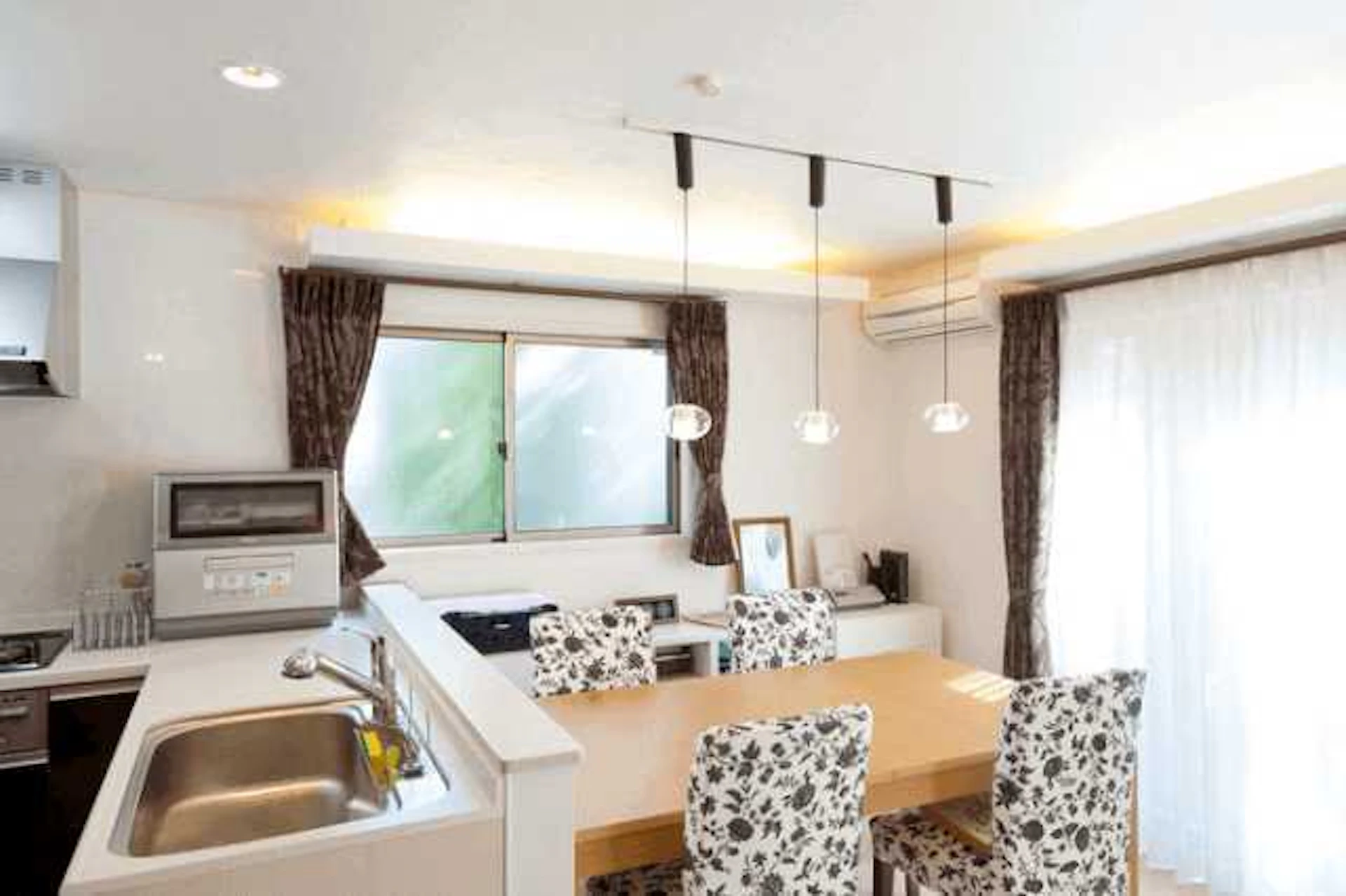 食洗器が置かれたL型キッチンが入ったダイニングルーム