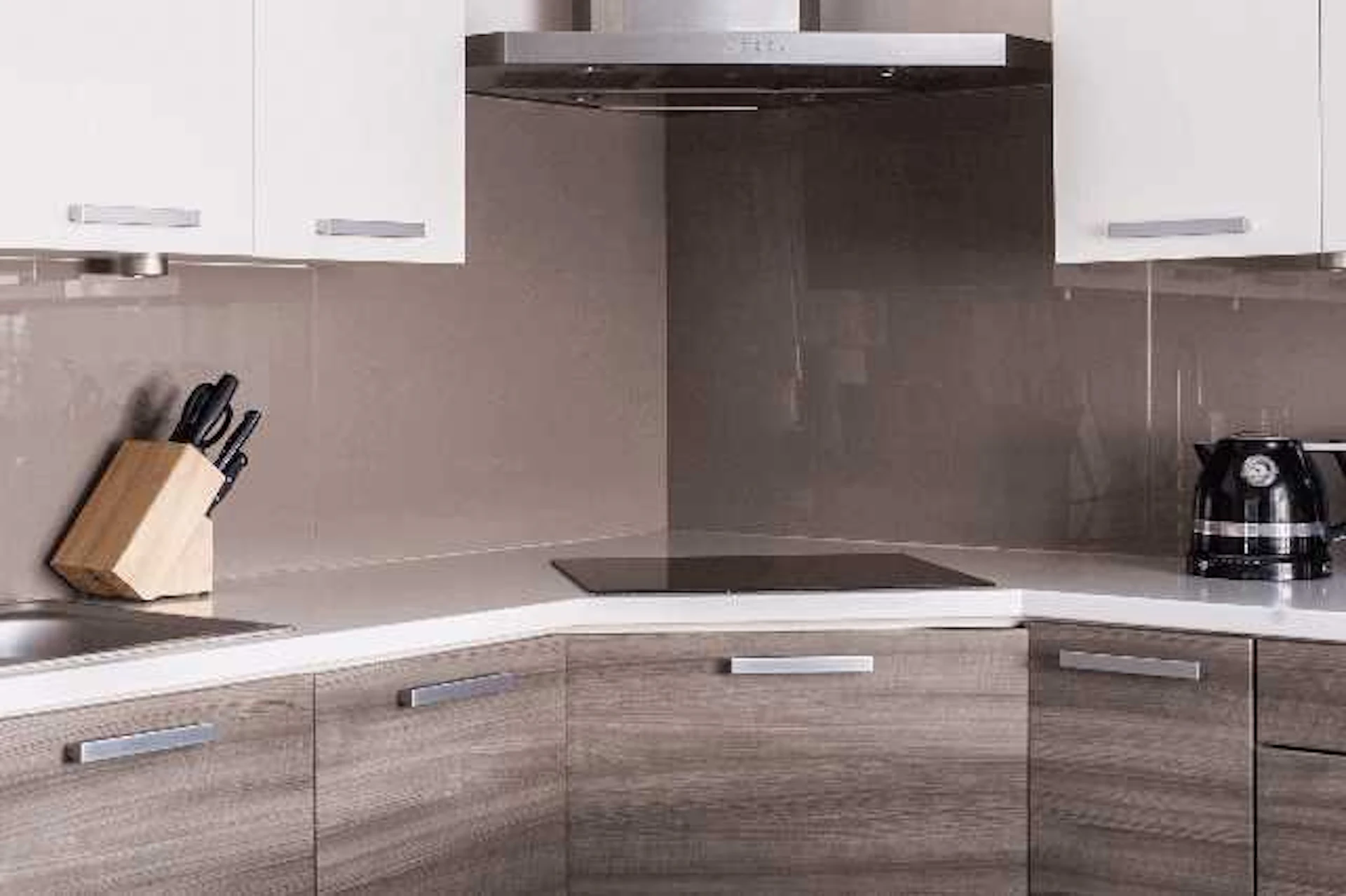 茶色い木目調のL型キッチンと白い収納棚の写真