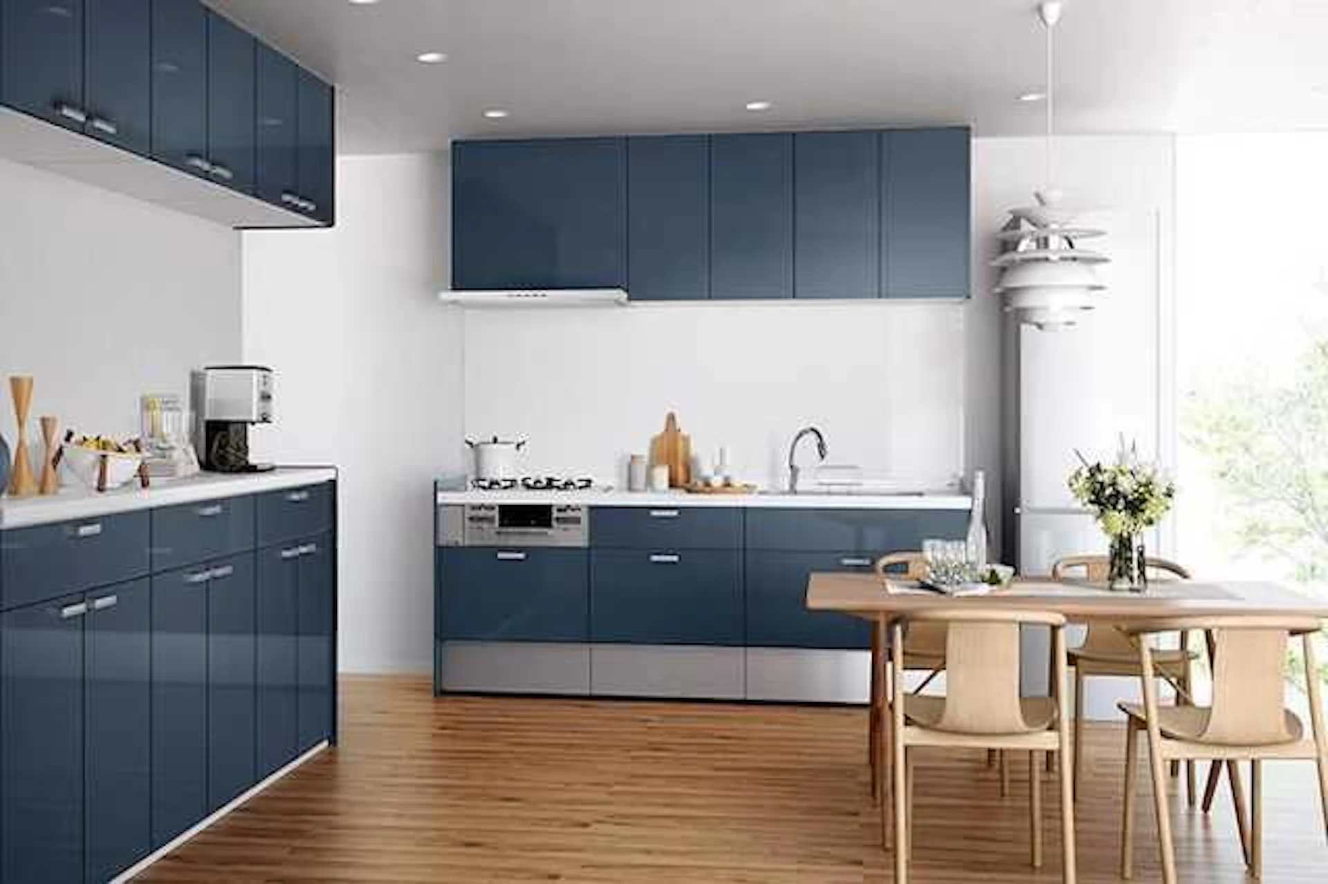 白い壁、フローリングに映えるネイビー系のシステムキッチン