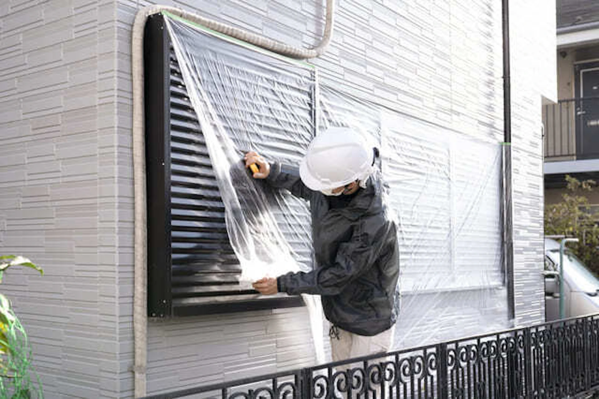 雨戸を養生する塗装工事の男性作業員