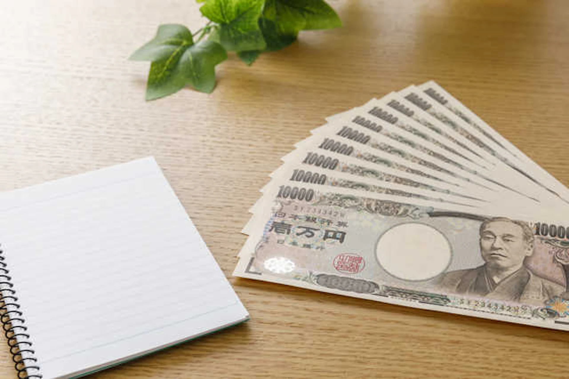 一万円札の束とリングノート