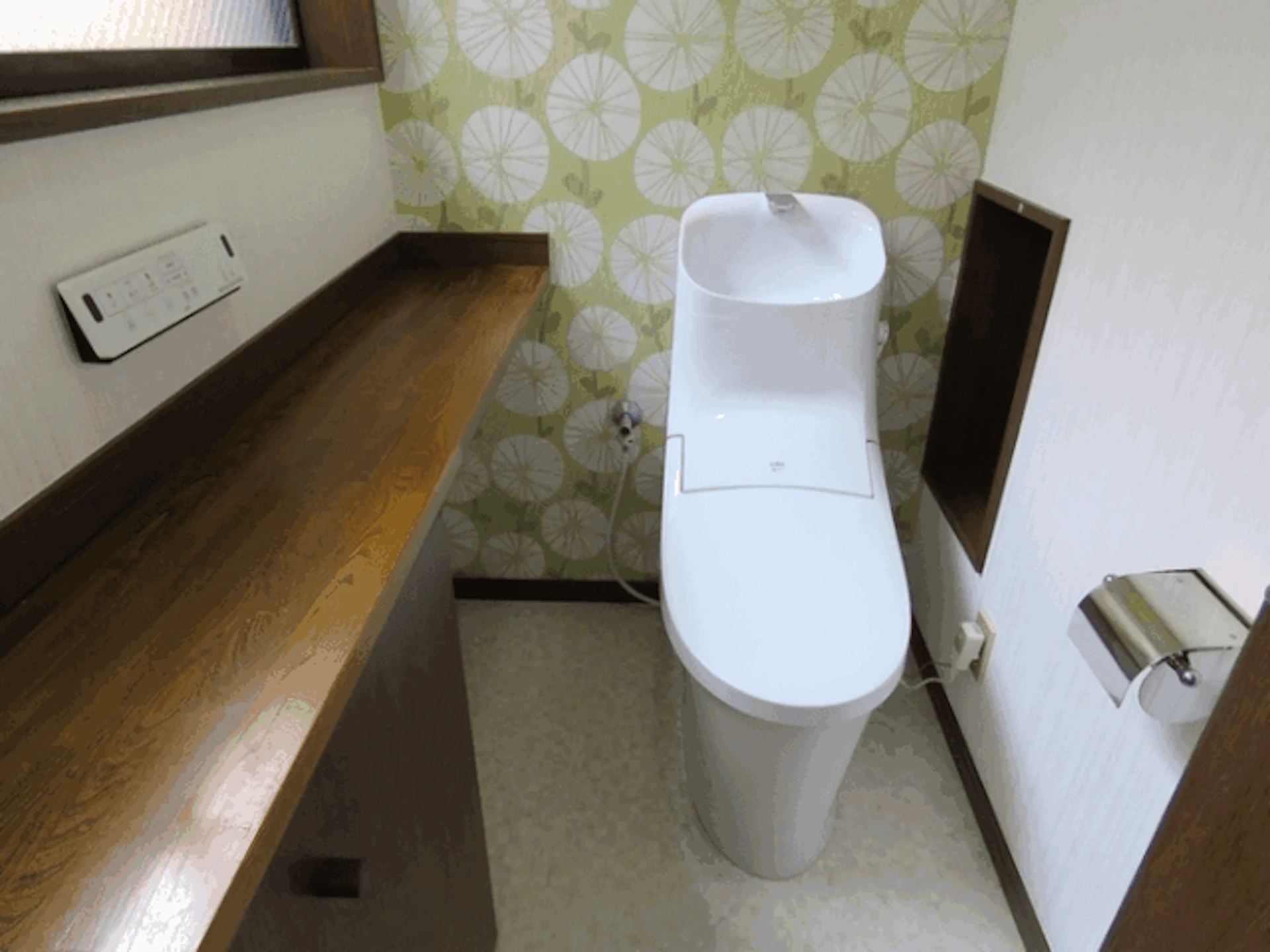 手洗い器付きのシンプルな形の一体型シャワートイレと、爽やかなイエローグリーンを一面だけに施した壁