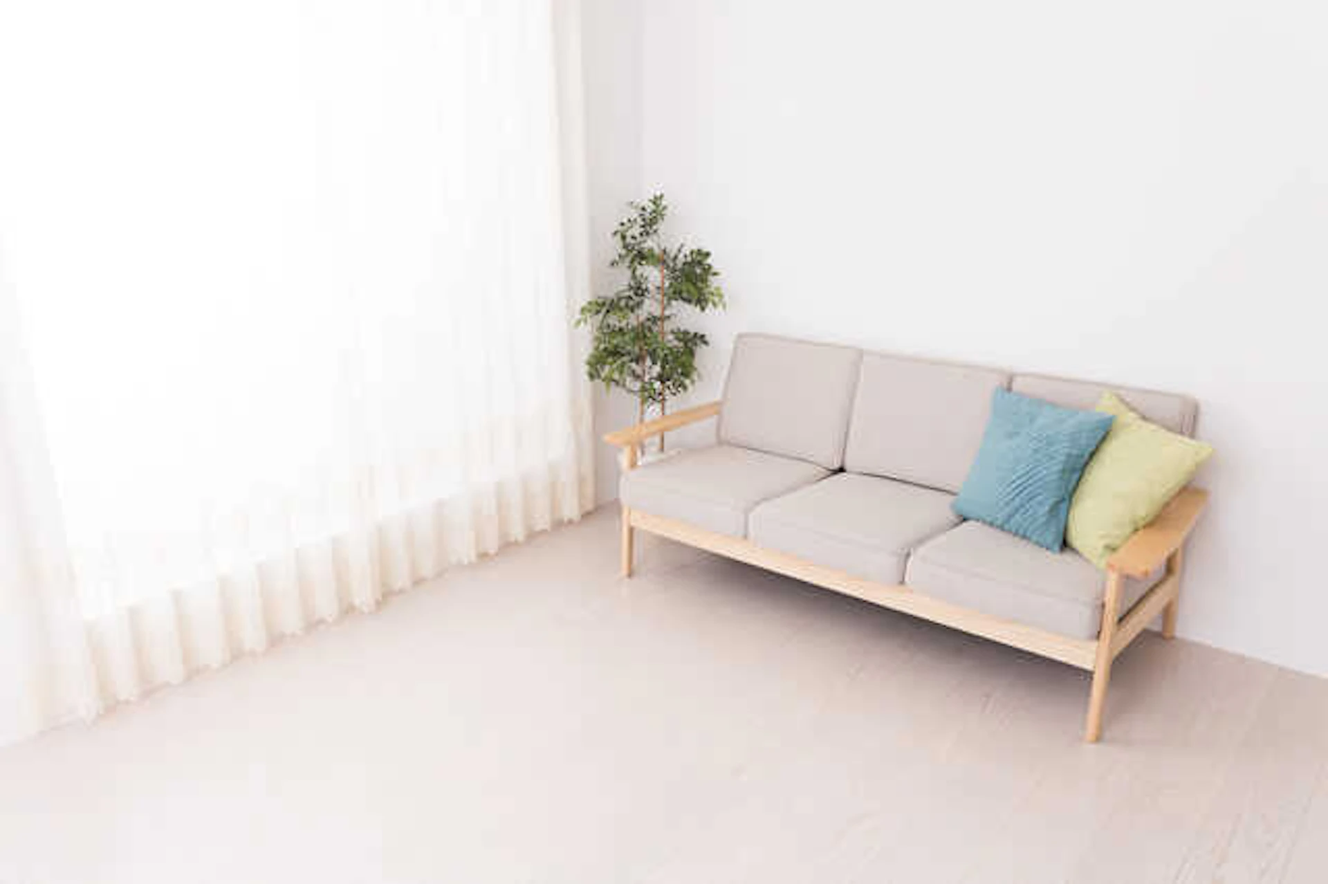 淡い色調のリビングルーム、ベージュのソファが置かれている