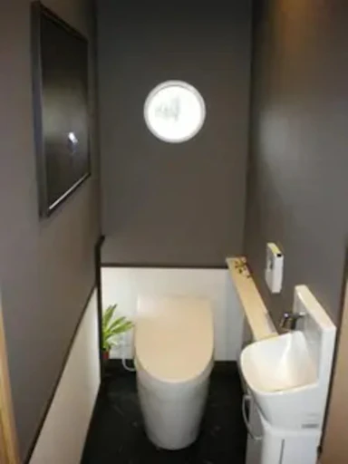 スリットから漏れる光とシックなトイレ