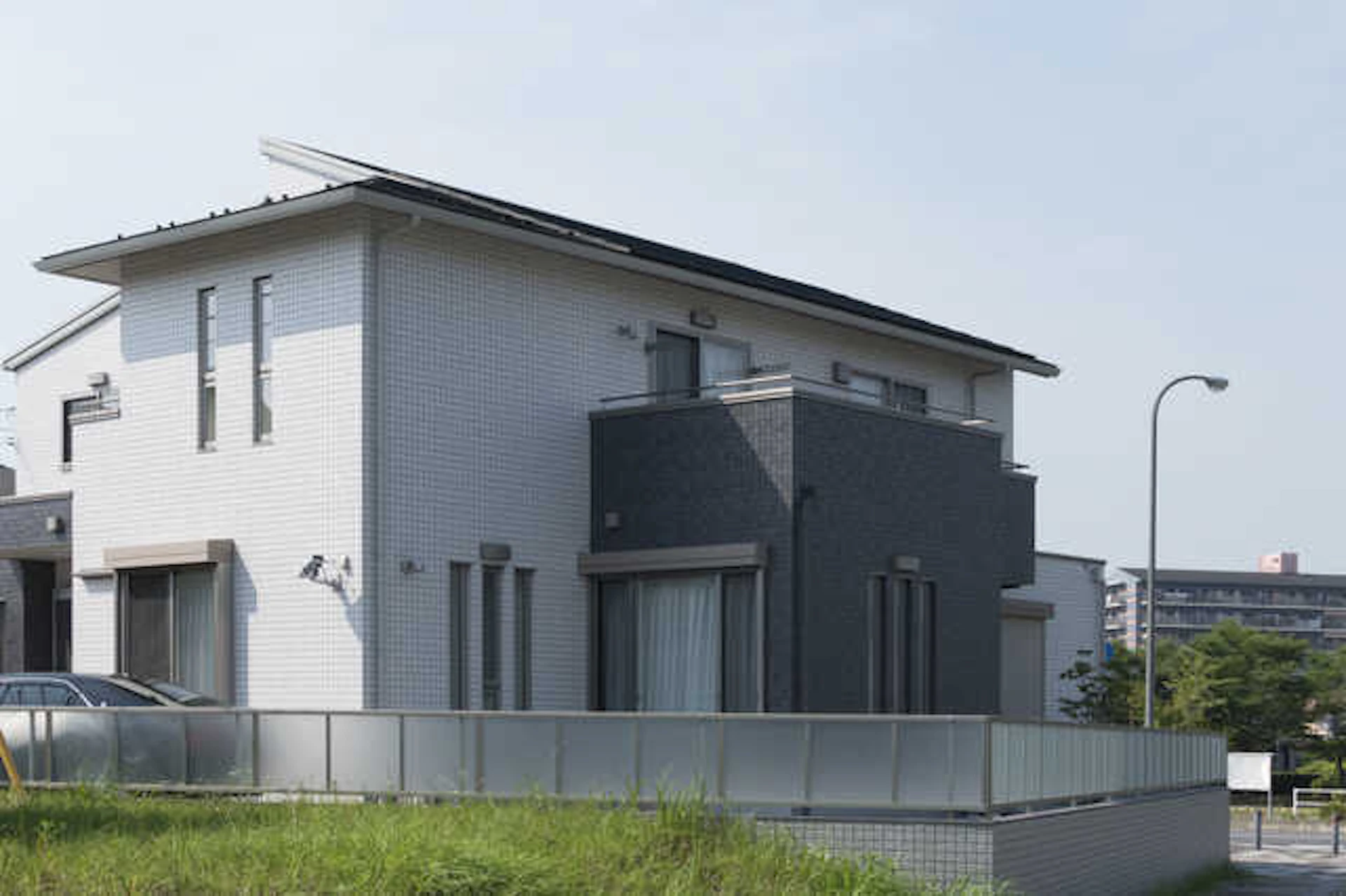 白とグレーの外壁がある一戸建てと、その外構