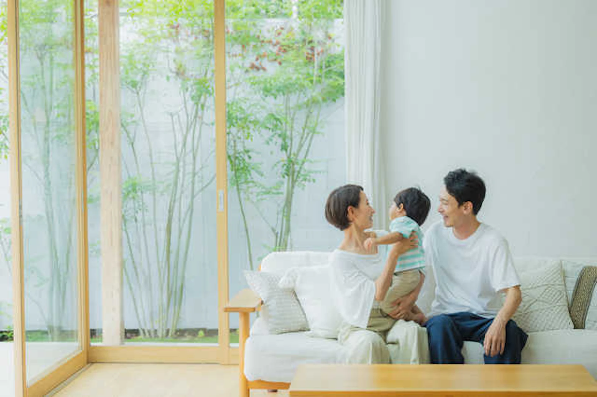 リビングで赤ちゃんと遊ぶ若い夫婦