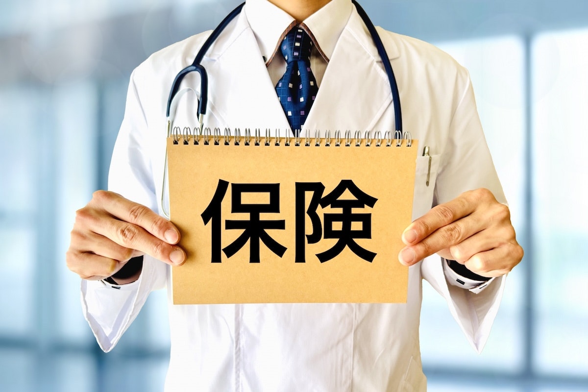 白衣を着た男性の手元