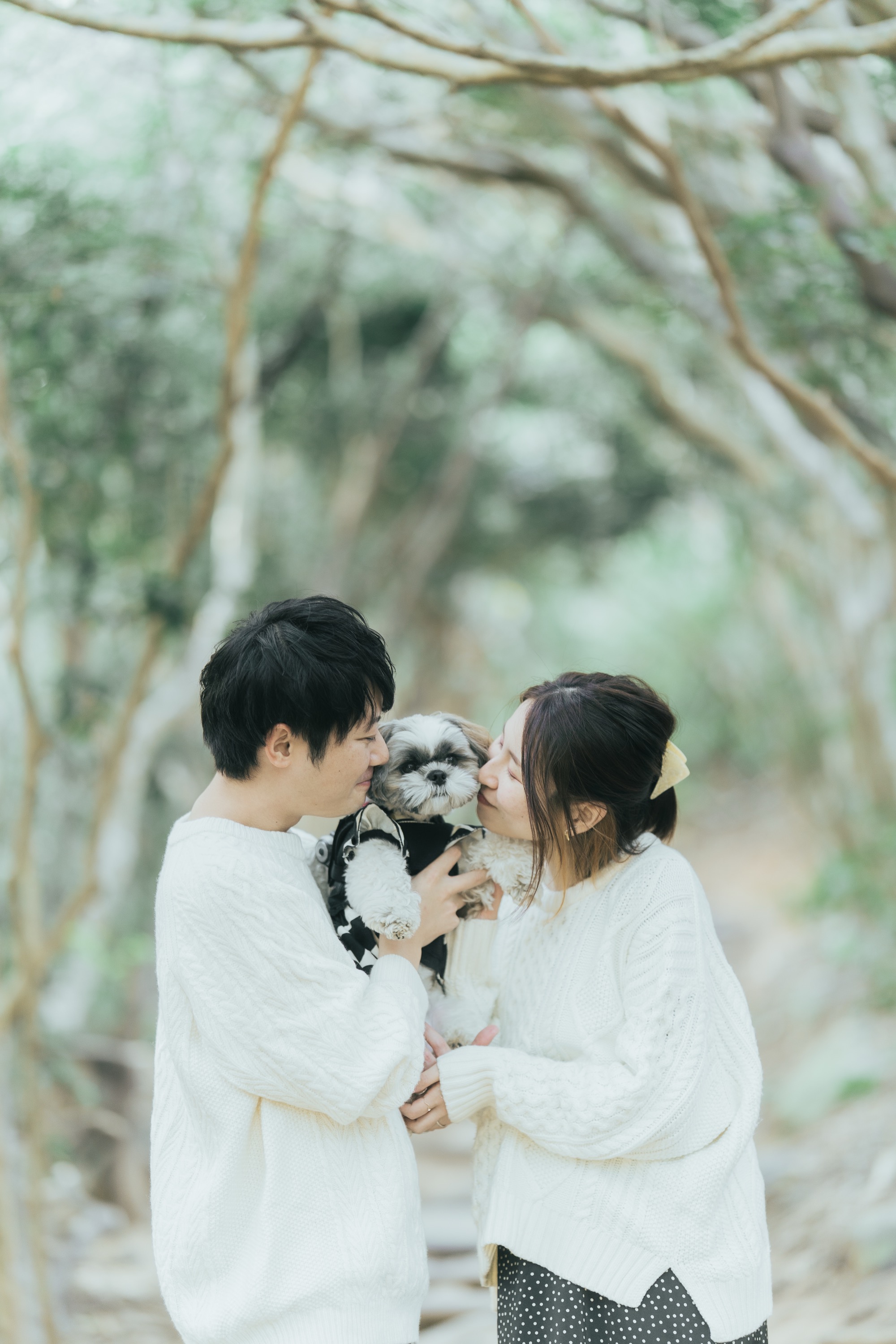 トトロの森で愛犬を抱いて見つめ合う夫婦