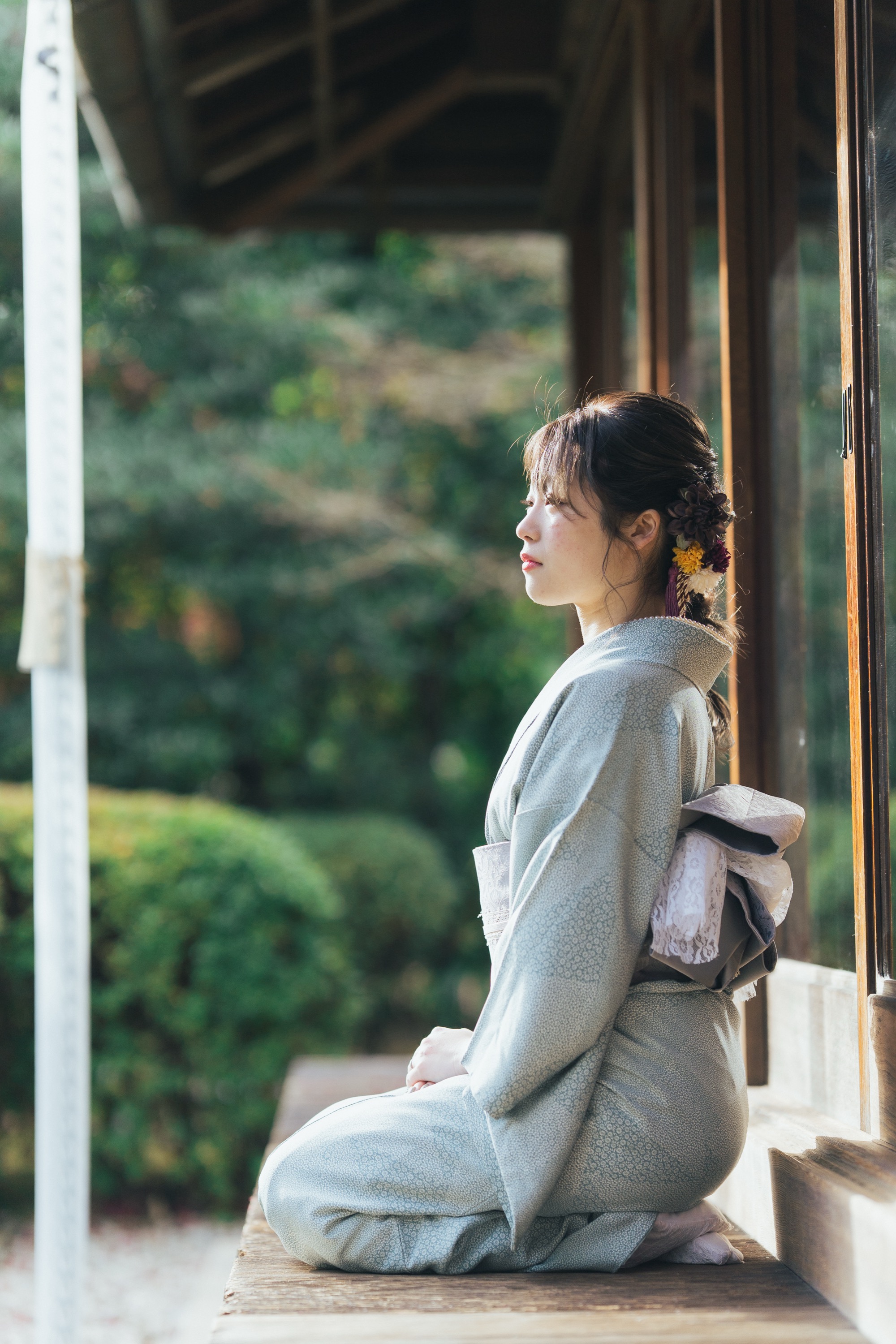 縁側から庭を眺める着物姿の女性の横顔