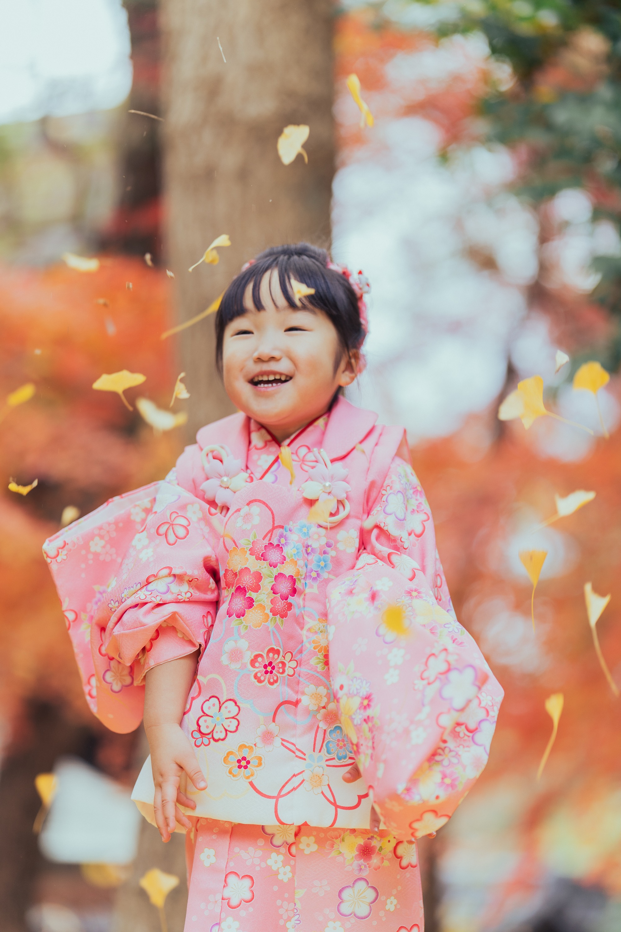 イチョウの葉が舞う中で笑う妹