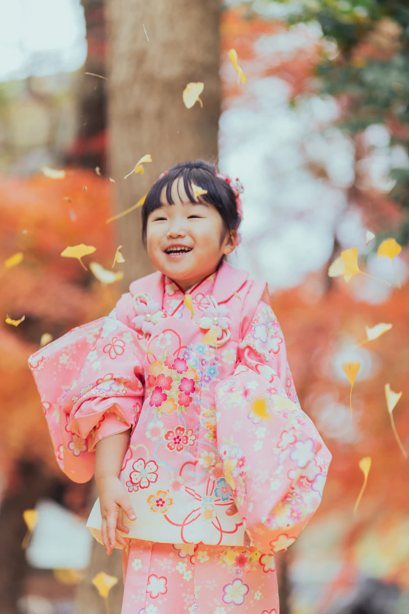 イチョウの葉が舞う中で笑う妹