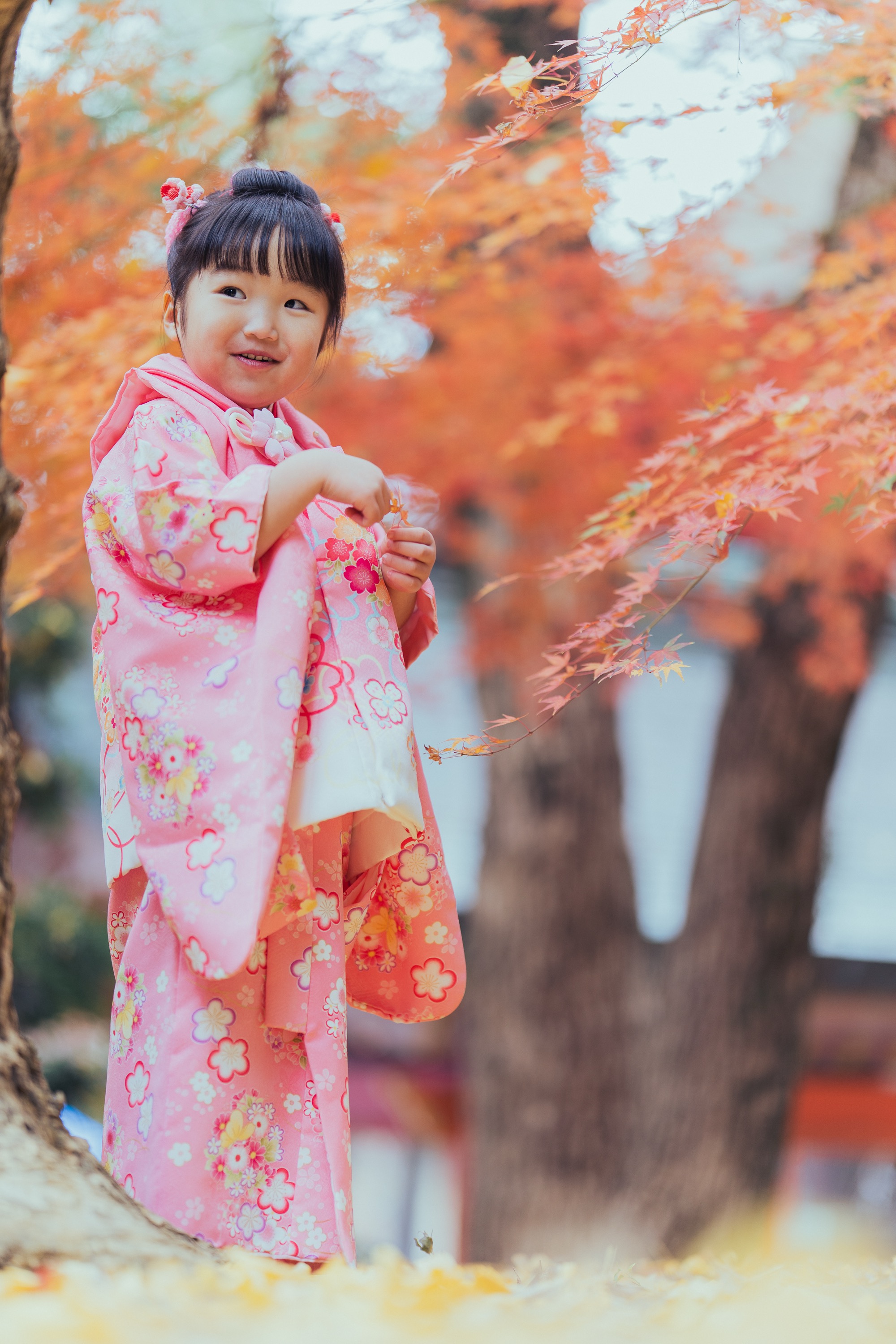 紅葉の前で微笑む妹