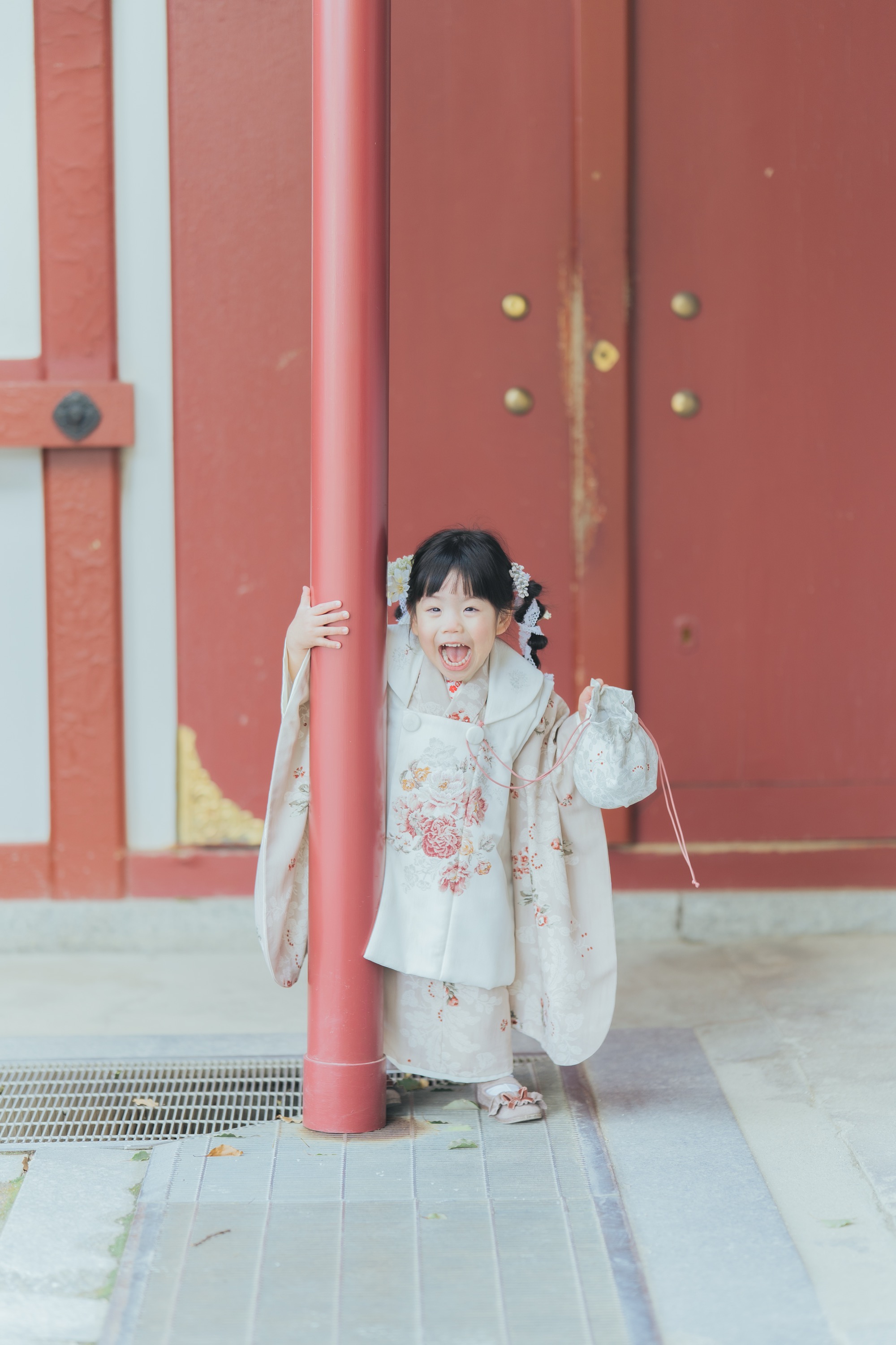 柱の陰からにっこり顔を出す女の子