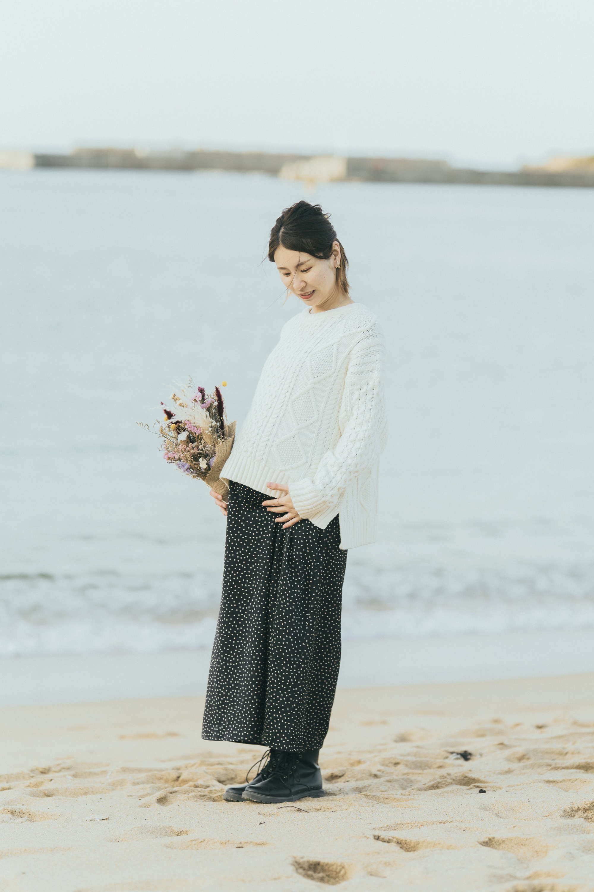 花束を持ちお腹を撫でる奥さま