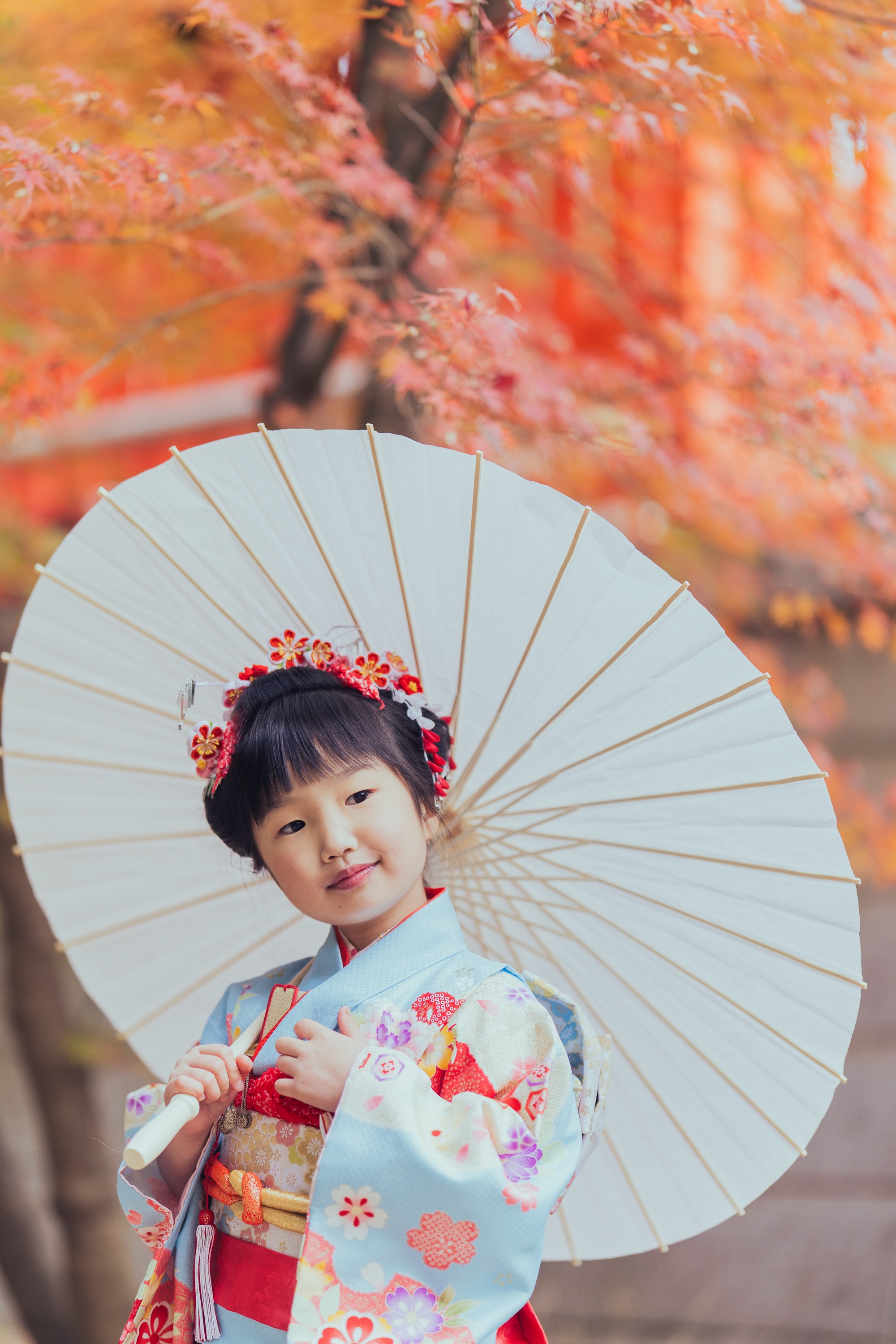紅葉をバックに和傘を持つお姉ちゃんのアップ