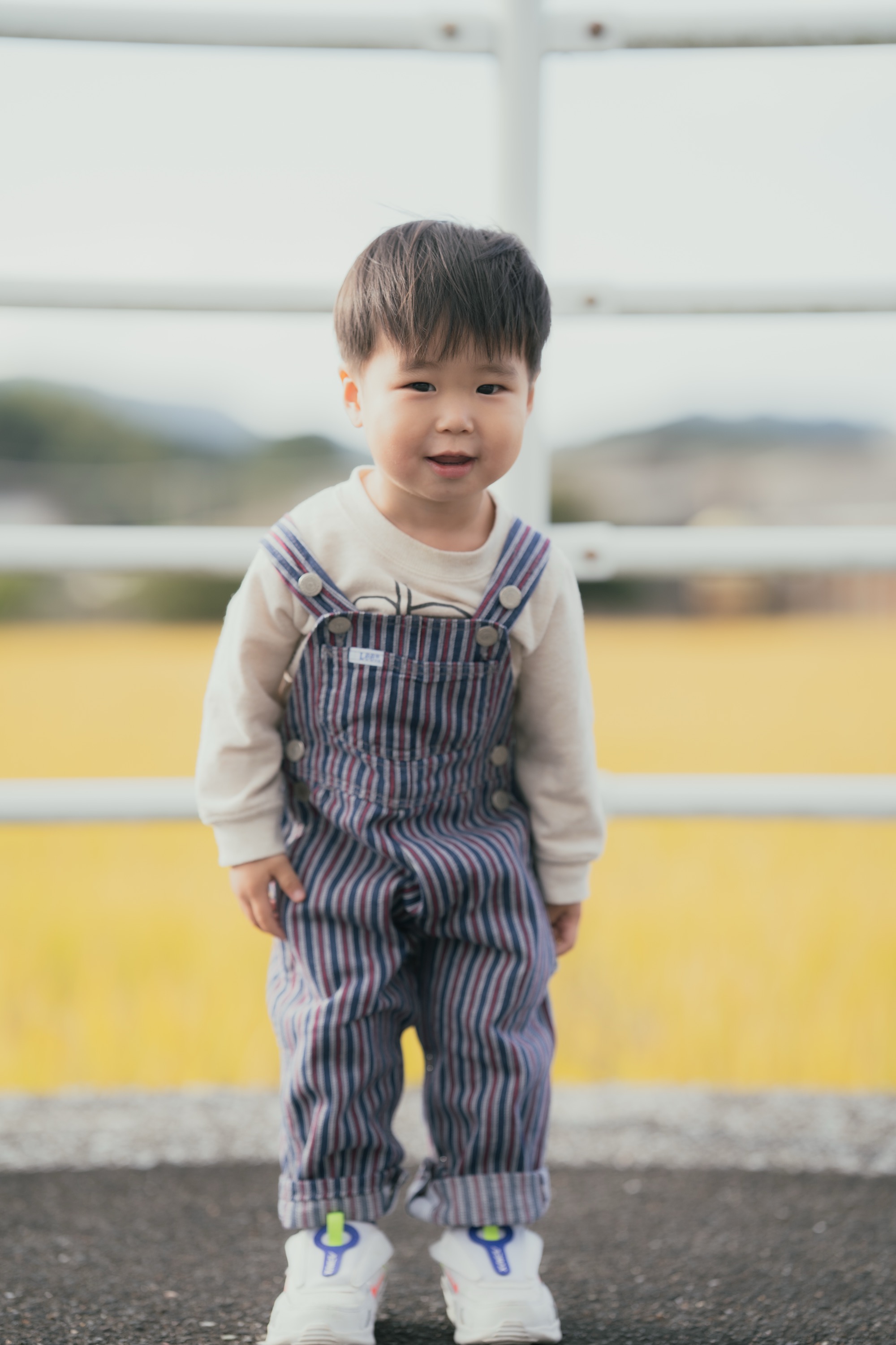 田んぼの前で笑顔の男の子