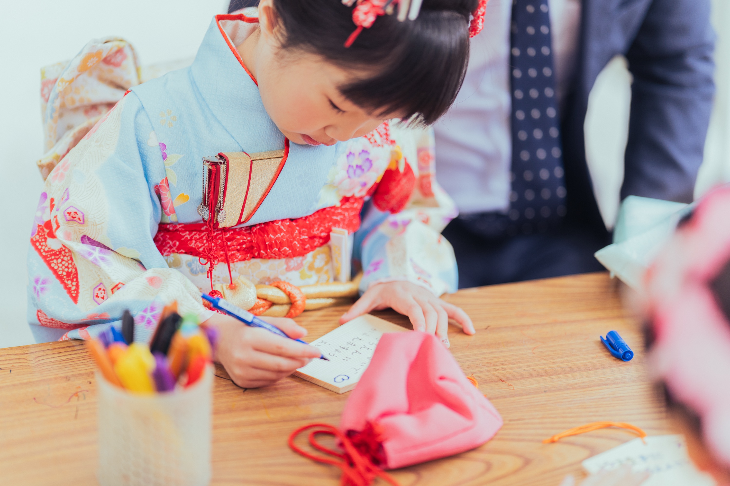 お姉ちゃんが一生懸命絵馬に願い事を書いている