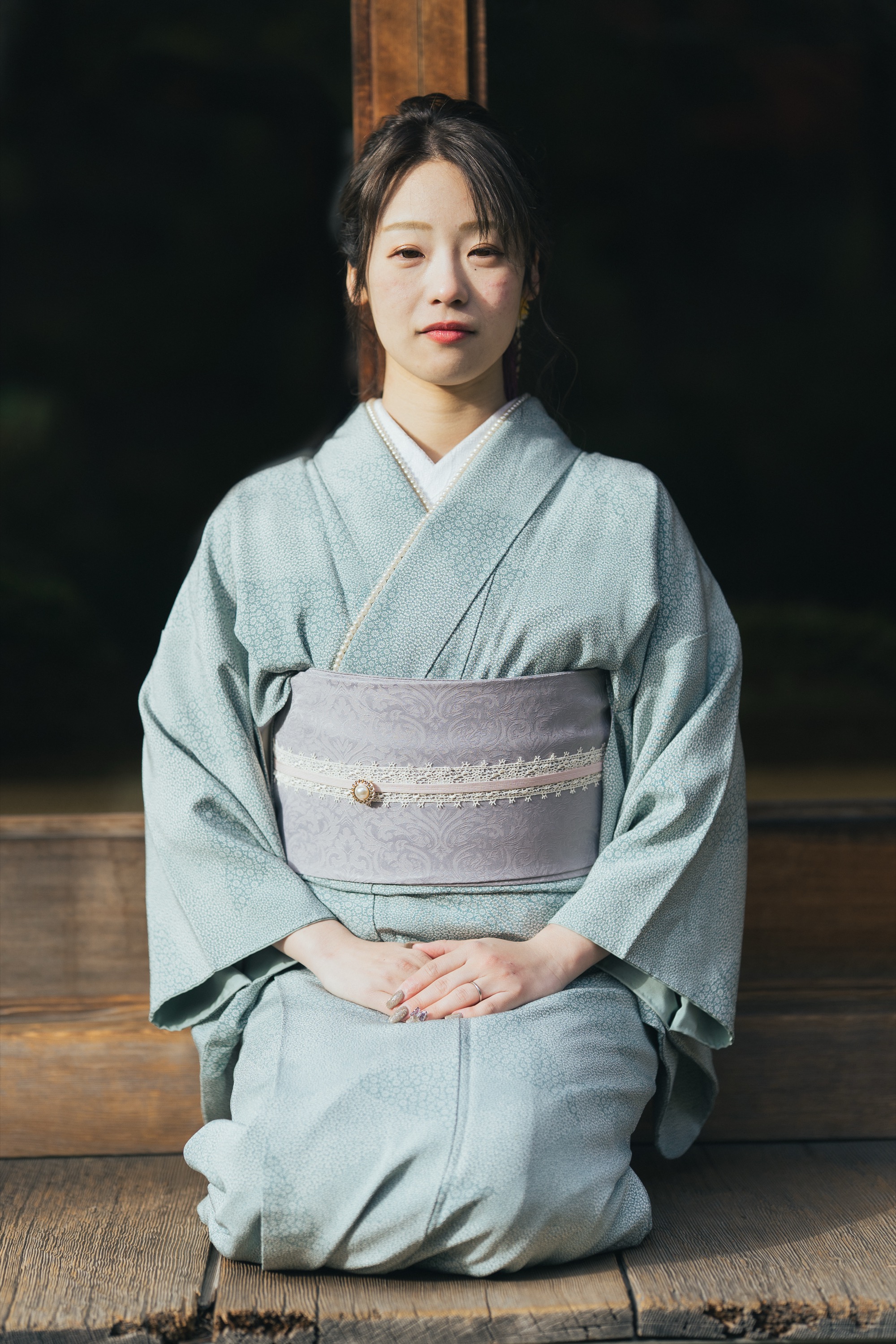 縁側に正座する着物姿の女性