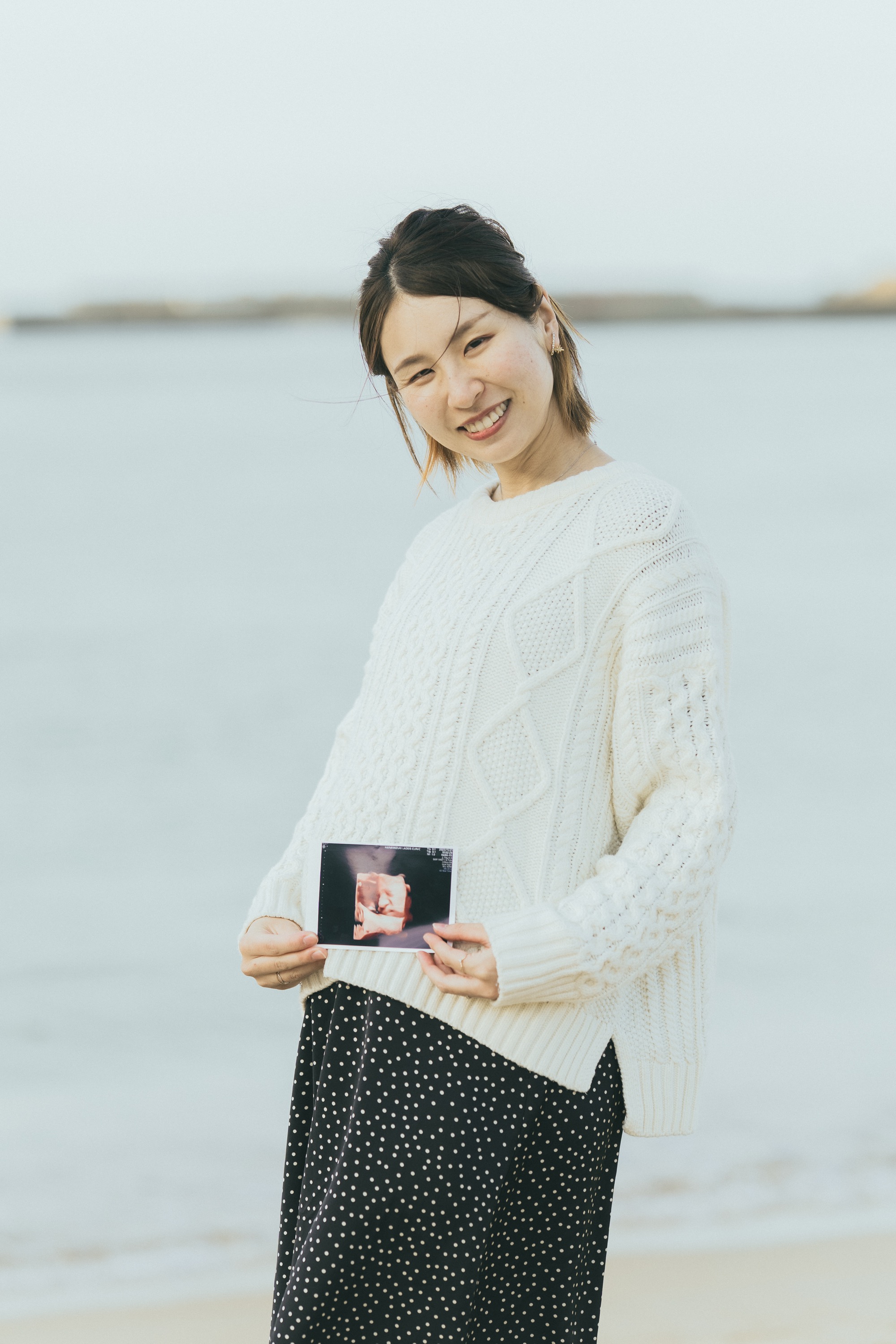 エコー写真を持って微笑む奥さま