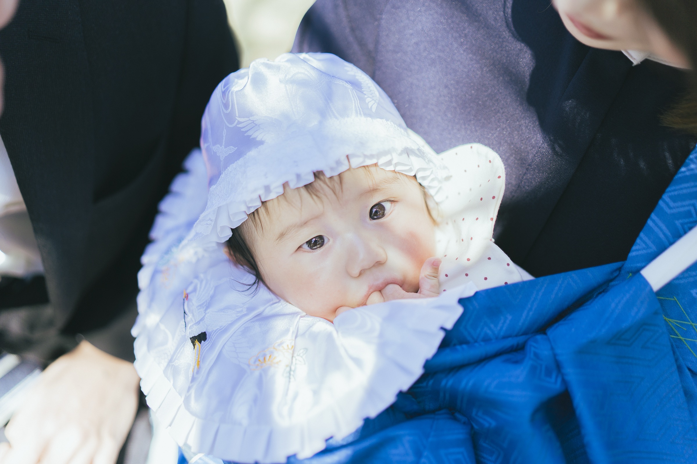 指しゃぶりをしながらカメラを見つめる赤ちゃん