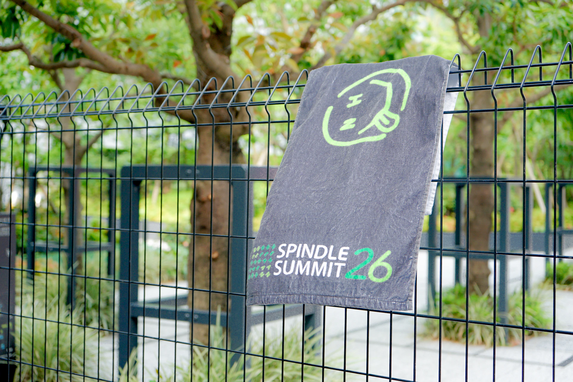 フェンスにかかってるSpindle SUMMIT2026 NEHANのオリジナルタオル