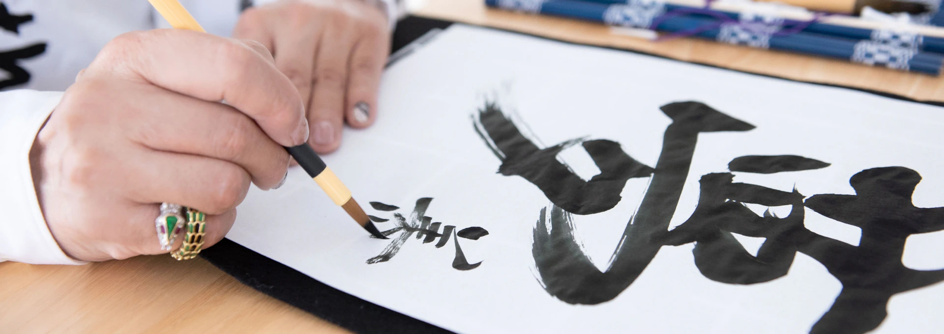 【画像】美川さんが筆で書いているところの手元のアップ。半紙には夢と書かれている。