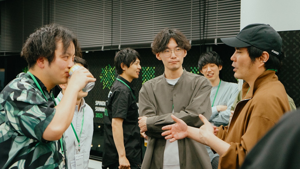 懇親会での交流風景。複数の参加者が飲み物を片手に会話を楽しんでいる様子。