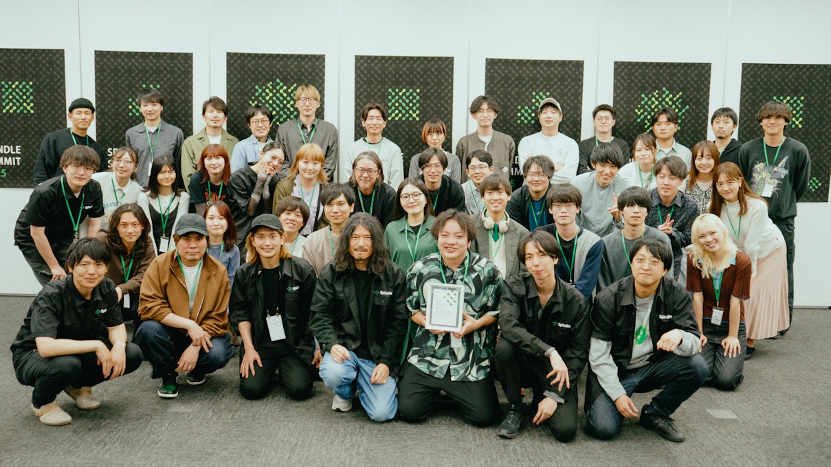 Spindle SUMMIT 2025の全参加者による集合写真。前列中央には賞を受賞した参加者がトロフィーを持ち、皆が笑顔でカメラに収まっている。