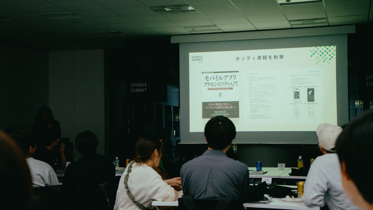 「ホンディ書籍を執筆」と題されたスライドが表示されており、ホンディ氏が執筆した書籍『モバイルアプリアクセシビリティ入門』の表紙と内容の一部が紹介されている。