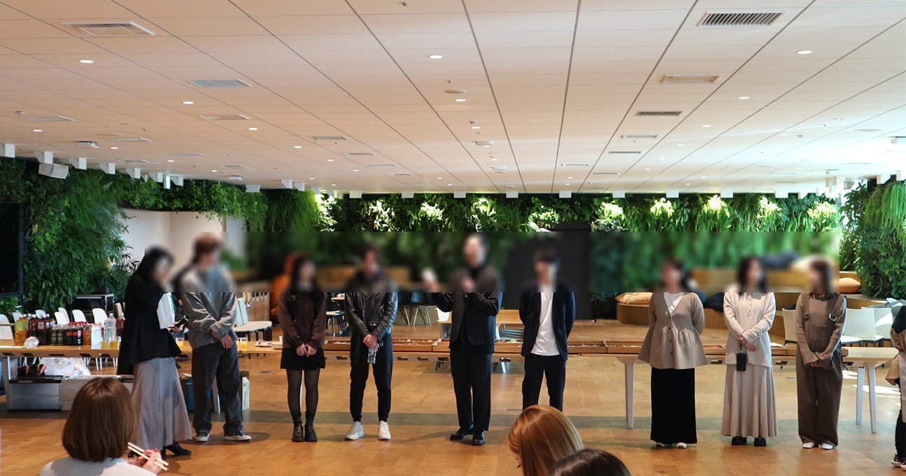 横一列に並んだ9人の男女の写真