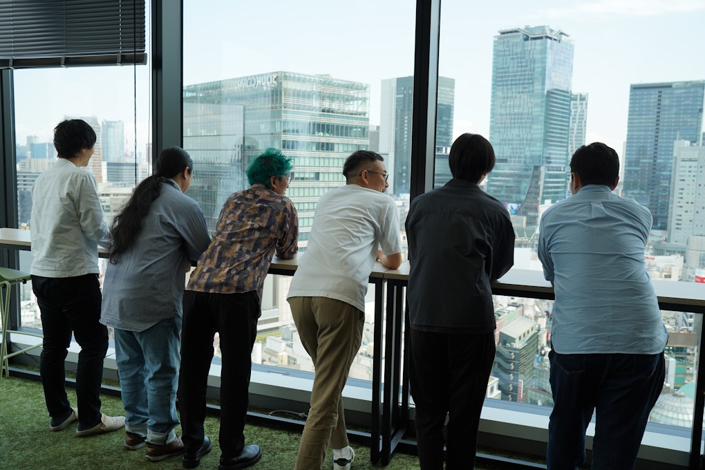 渋谷の街を眺め、お互いの労をねぎらうプロジェクトメンバー達