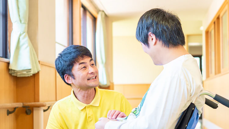 ご利用者の男性と談笑する介護職員の男性