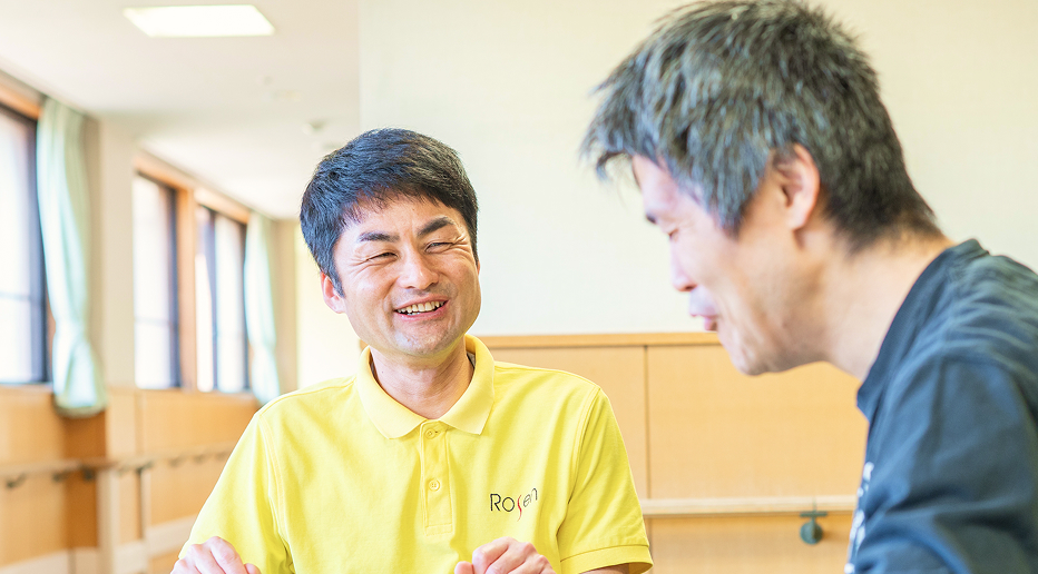 ご利用者の男性と笑顔で会話する介護職員の男性