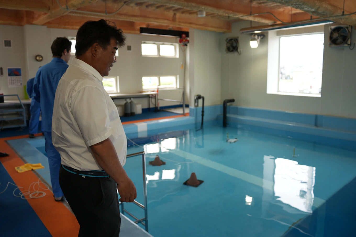 訓練用プールと水中機器を見つめる中村さん