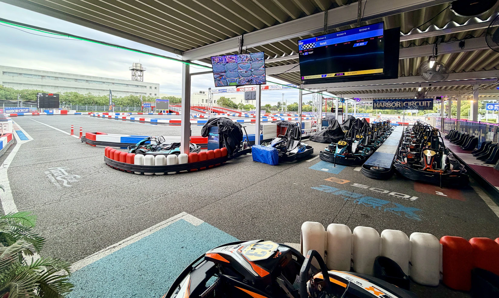 奥にはサッカー場ほどの広さのサーキット。手前にはピットがあり大人用カートが20台ほど止まっている