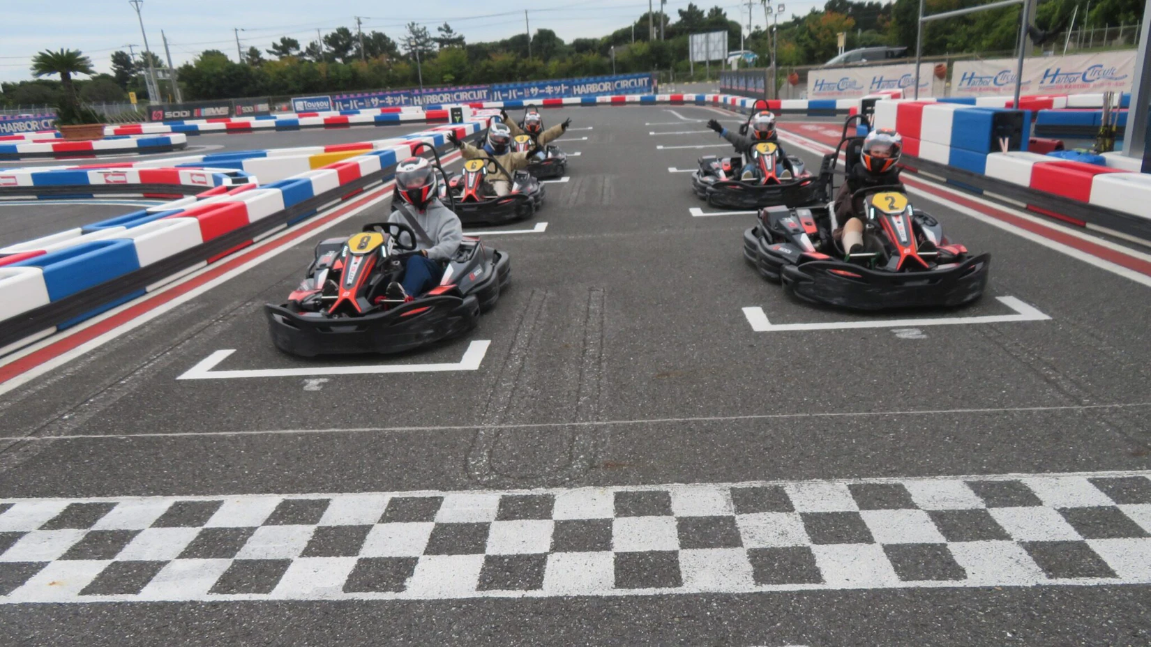 サーキットのスタート位置にて左右に2台ずつ合計5台のカートが並んでいる。みんなこっちに向かって各々楽しそうにポーズをとっている。