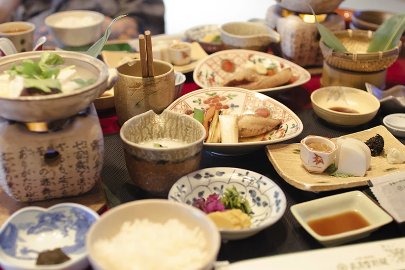 四季の湯 座敷武蔵野別館の朝食、テーブルいっぱいに料理が並んでいる