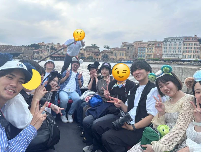 アトラクション ヴェネチアン・ゴンドラの船上で撮影した集合写真。園内のメディテレーニアンハーバーを背景に、メンバーが笑顔で写り込んでいる。