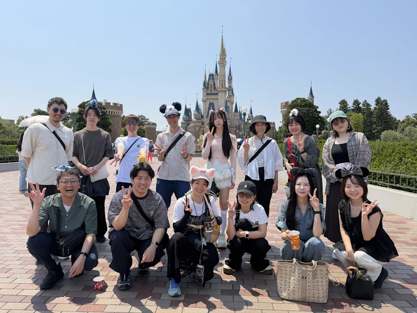 ディズニーランドで集合写真を撮る社員の写真。