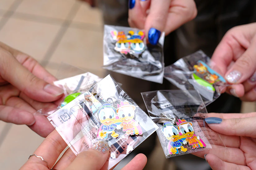 ゲームを終えてゲットしたドナルドのストラップを持つ5人の手