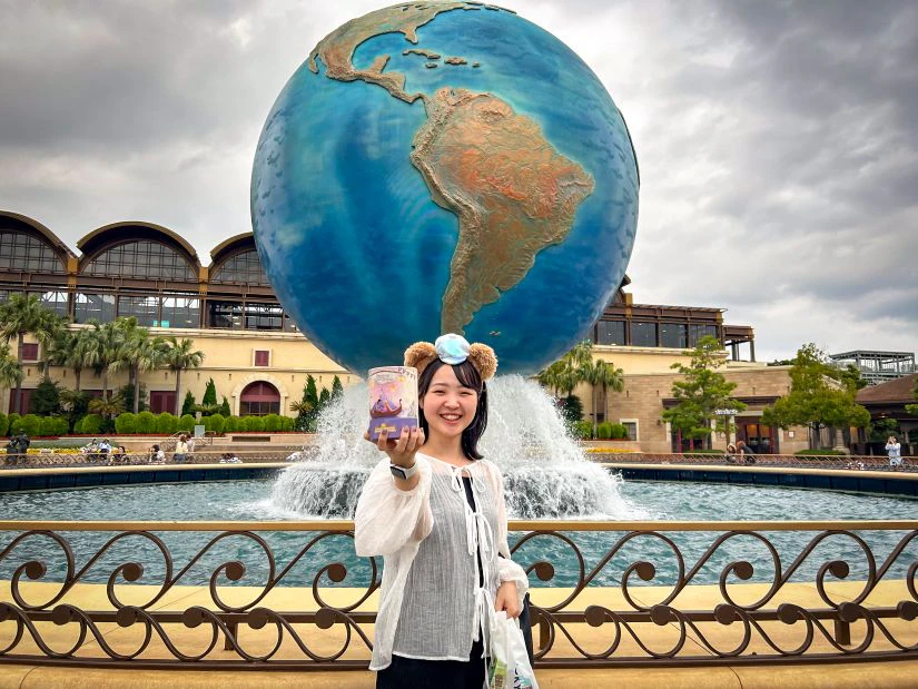 会社から支給された軍資金で買い物を楽しむ女性メンバー。ディズニー映画 ラプンツェルをモチーフにしたお土産を片手に、楽しそうに笑っている。