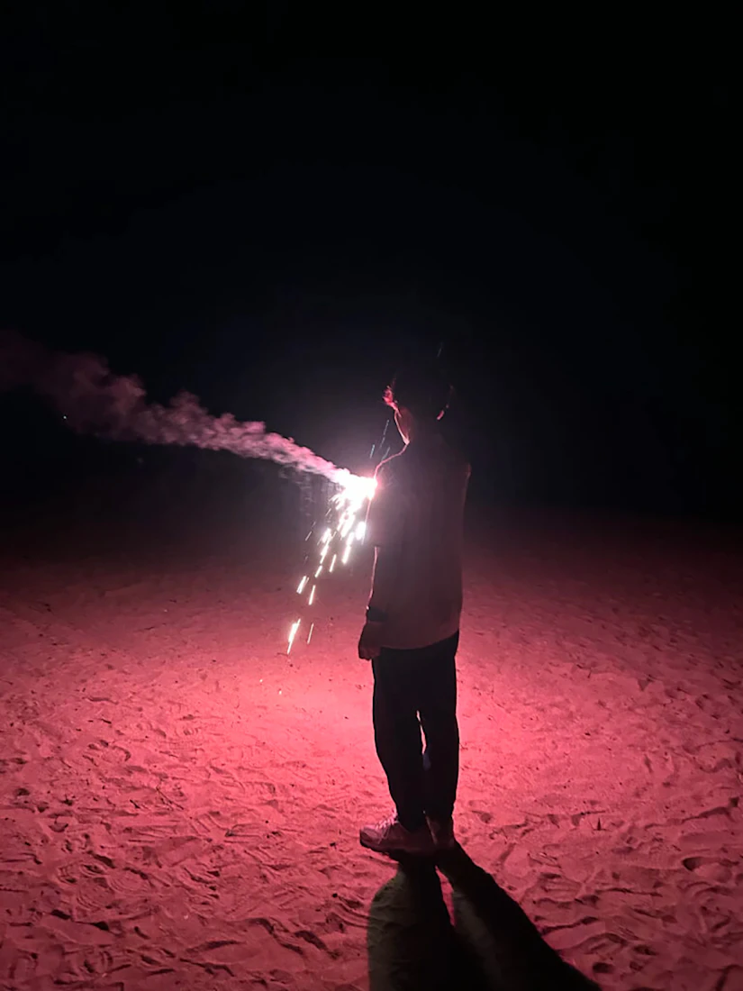 ノベルティ社員が手持ち花火を持っている後ろ姿。