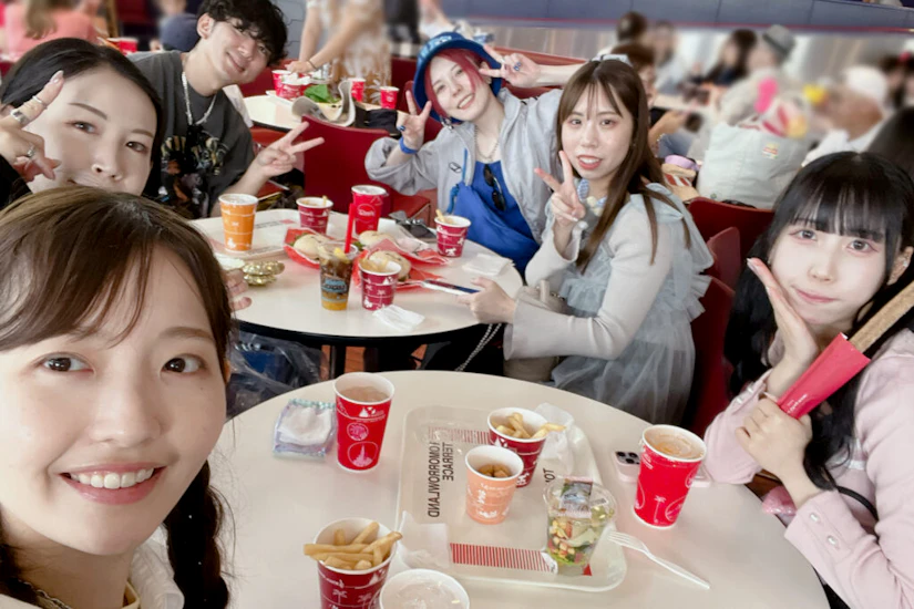 昼食を食べようとしているノベルティメンバー。ハンバーガーやポテトがテーブルの上にある。