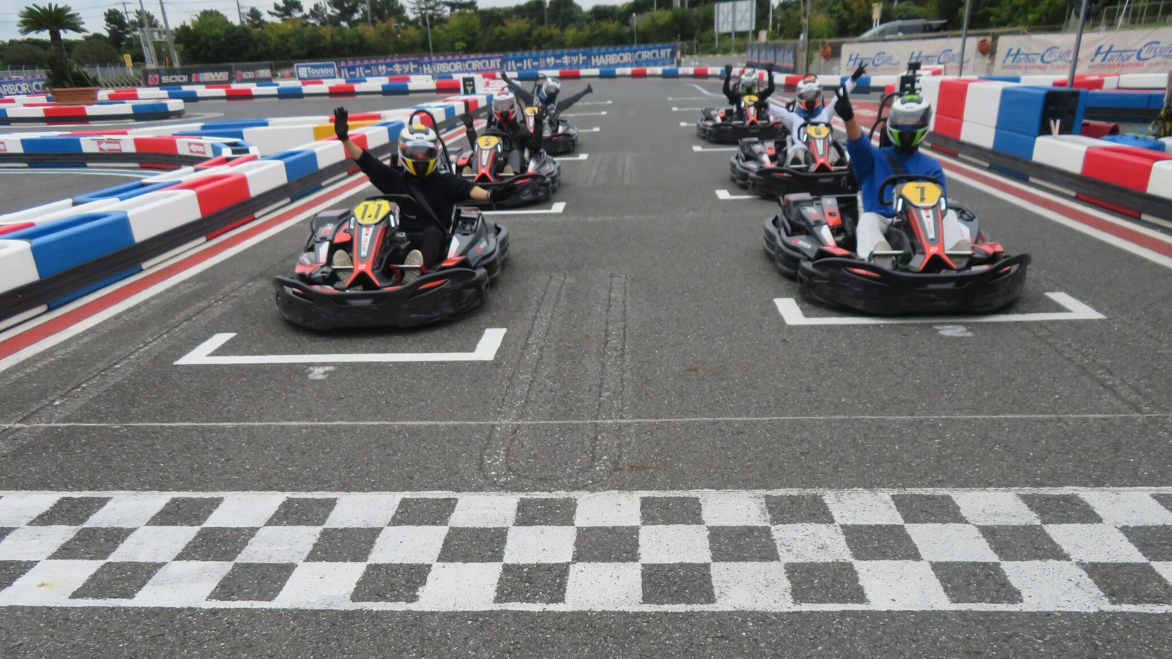 サーキットのスタート位置にて左右に2台ずつ合計6台のカートが並んでいる。みんなこっちに向かって各々楽しそうにポーズをとっている。